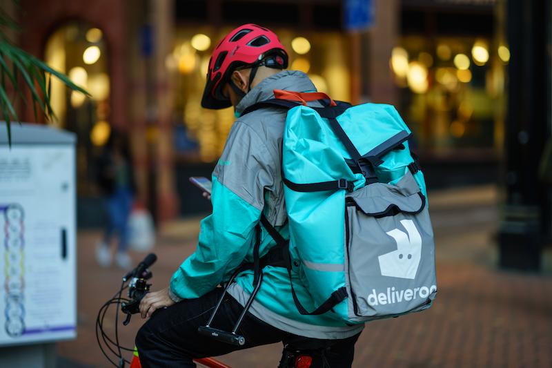Deliveroo delivery person on a bike carrying his Deliveroo backpack