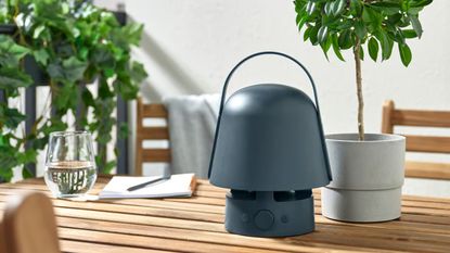 IKEA outdoor bluetooth lamp styled atop of a wooden outdoor patio set