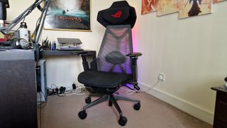 Asus ROG Destrier Ergo Chair in front of a multicoloured LED corner lamp