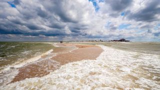 A strip of beach sits between two oceans