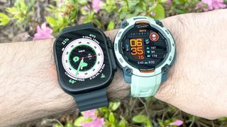 Close-up of the Apple Watch Ultra 2 next to the Garmin Instinct 3 on a user's wrist
