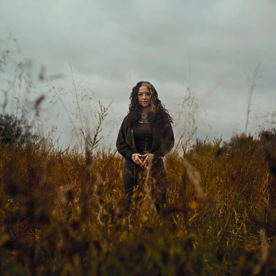 Ashley McBryde standing ina field