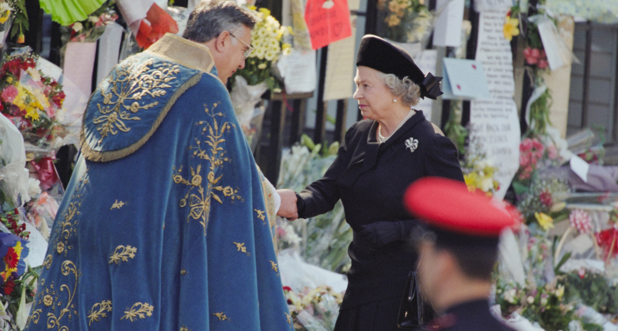Queen Elizabeth shaking hands with a clergyman at Princess Diana's funeral
