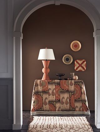 Brown hallway with a console table covered in ikat fabric