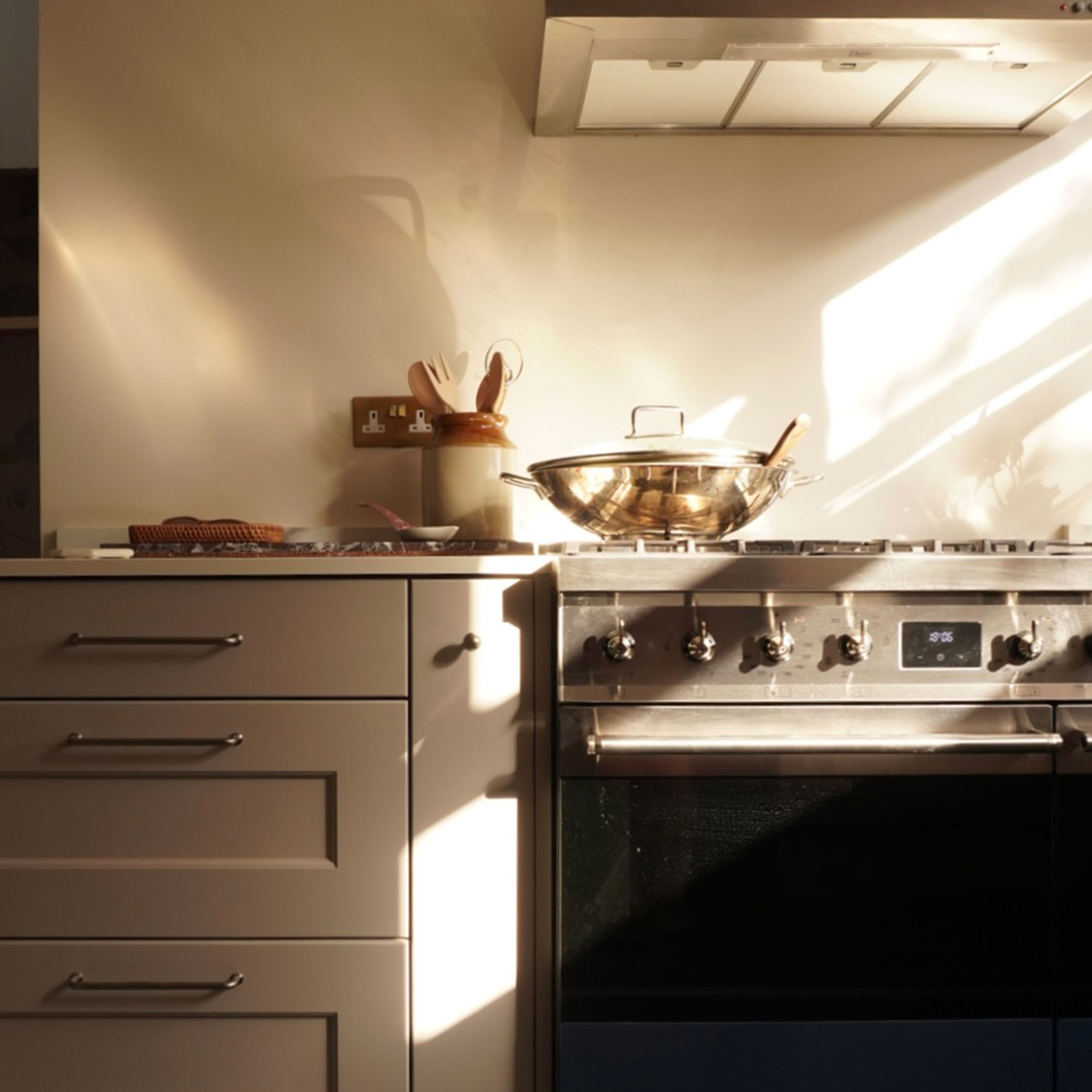 Neutral kitchen with grey cabinets and stainless steel stove