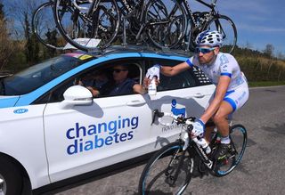 Andrea Peron gets a bottle from the Novo Nordisk team car