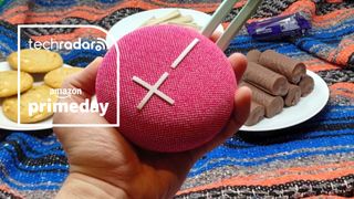 UE Miniroll at a picnic with Cadbury's Mini Rolls and cookies, held in a hand, with TR's Prime Day badge 