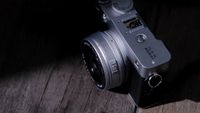 The Fujifilm XF 23mm f/2.8 R WR on a gray wood-like surface