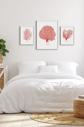 white bedroom with white bedlinen and pink artwork
