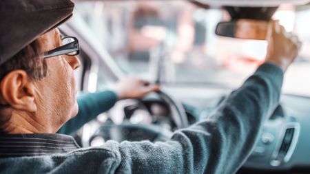 A man adjusting his rearview mirror 