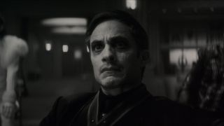 Gael García Bernal's Jack Russell stares at someone off camera in a black and white image from Marvel Studios' Werewolf by Night