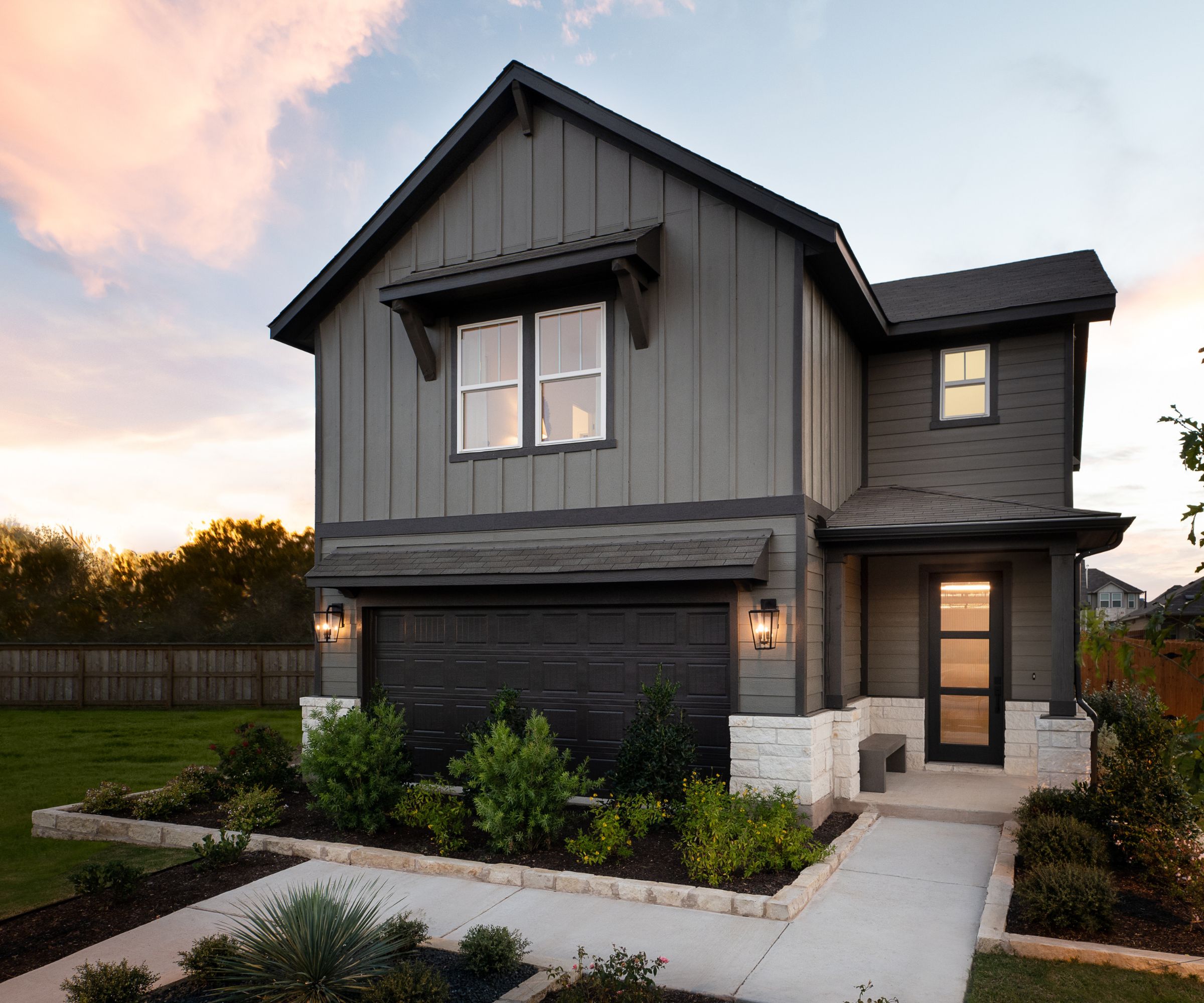 Dark green-gray house at dusk by Ashton Woods Homes