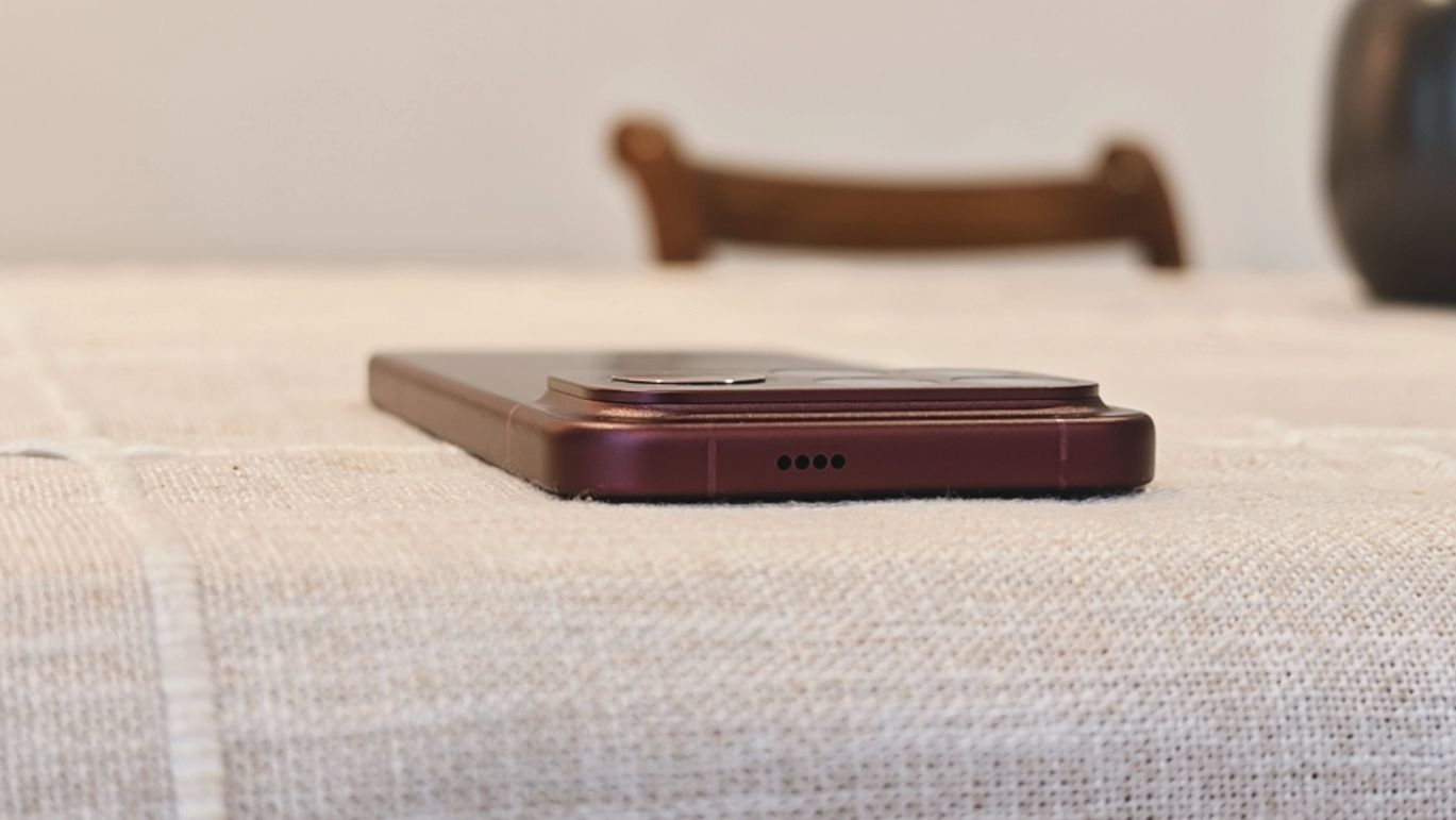 The Poco F9 Ultra being held in the hand and resting on a table