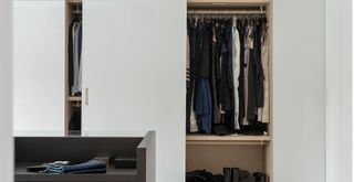 white wardrobes with a door open to reveal organised clothing inside to support the 90/90 decluttering method