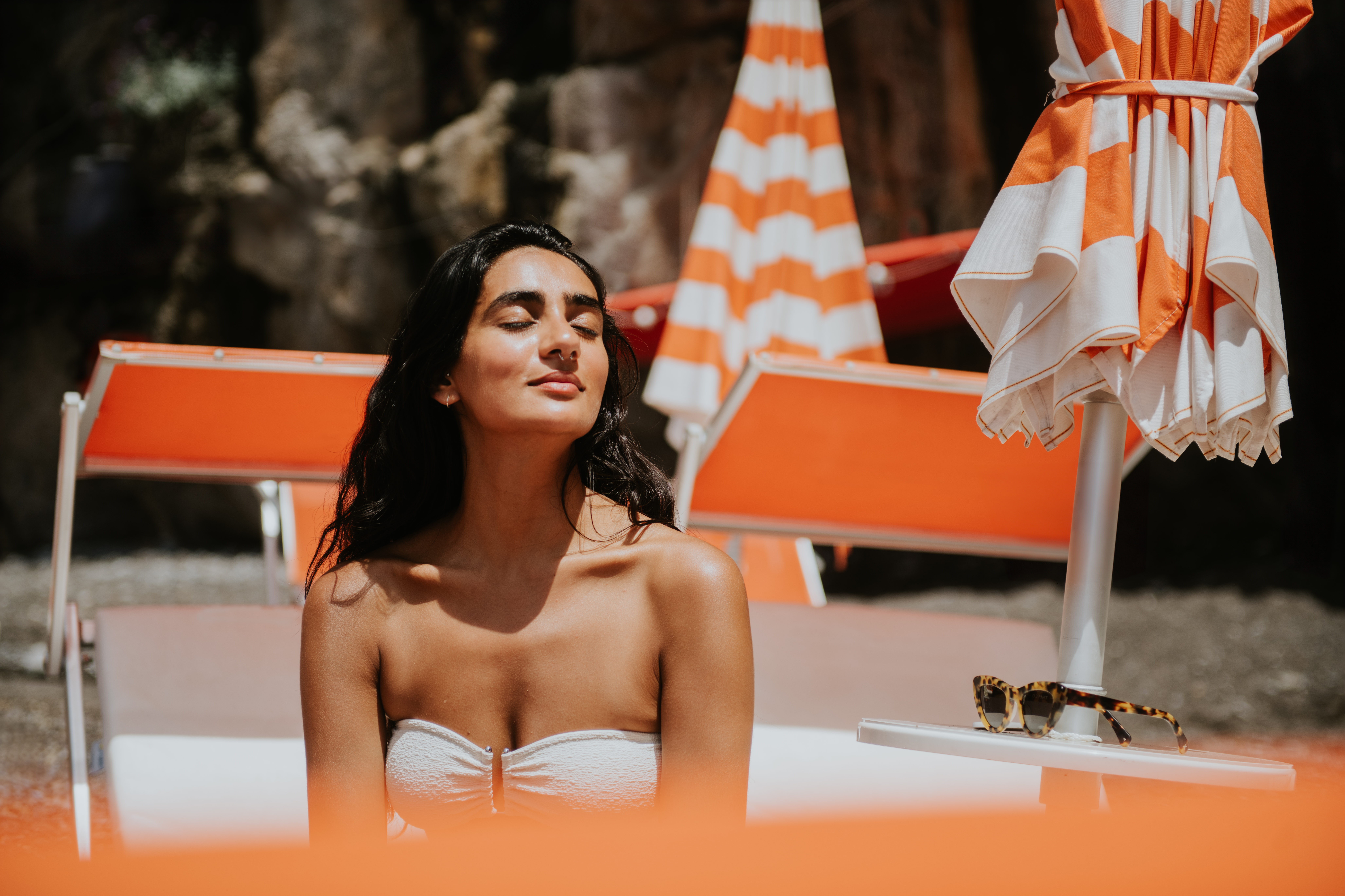 serene woman on the beach with orange umbrellas