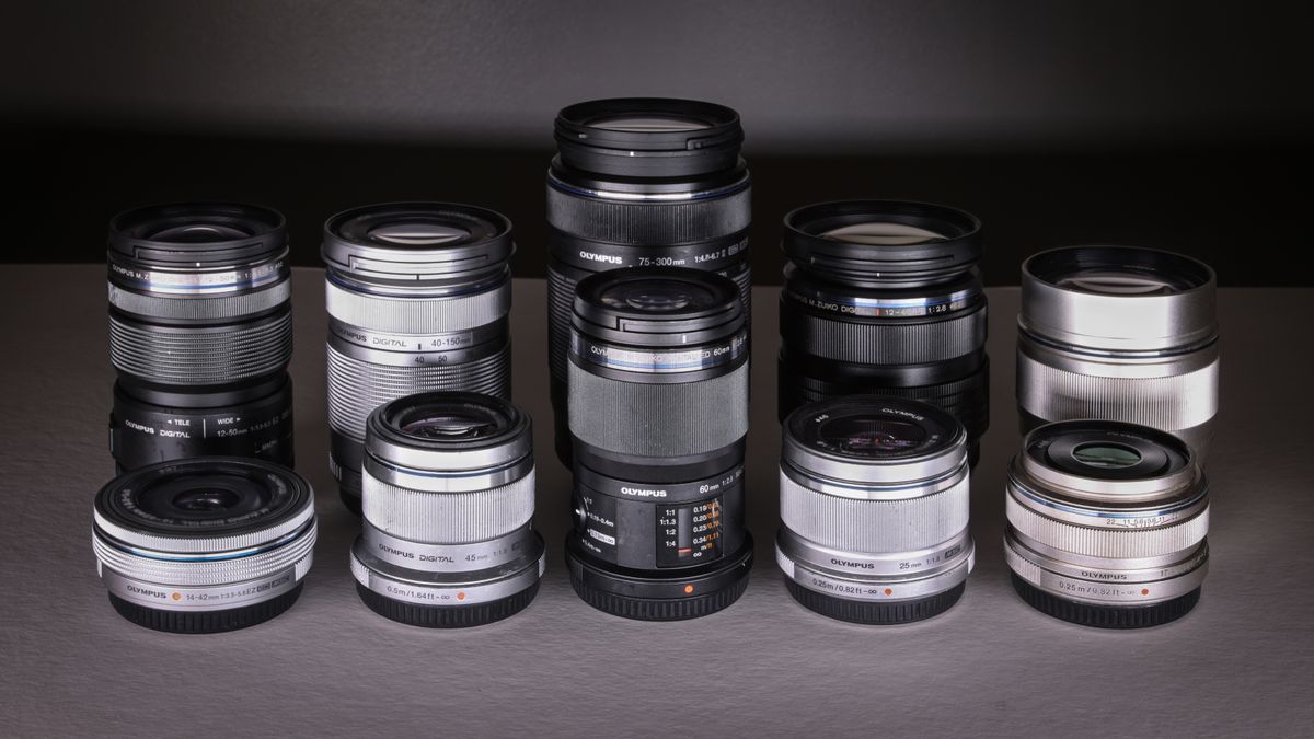 A selection of Olympus / OM System lenses on a grey surface