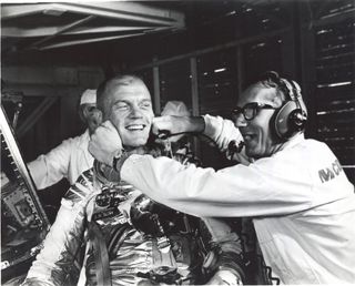 Guenter Wendt, the original pad leader for NASA's manned space program, coaxes a smile out of astronaut John Glenn after a launch scrub the month before his historic orbital flight in February 1962