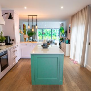 Kitchen with green kitchen island and cabinets