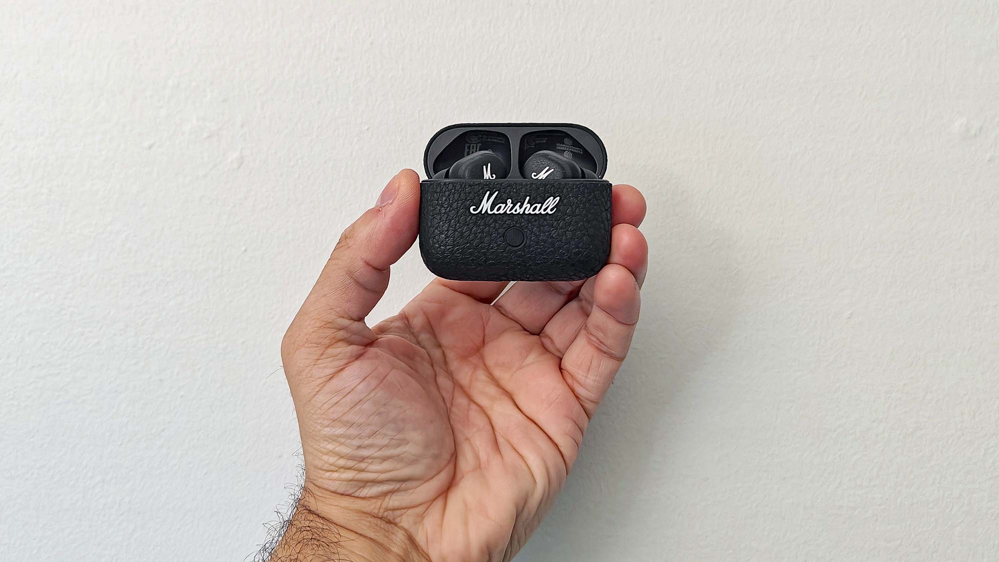 Marshall Motif II ANC in charging case held between fingertips