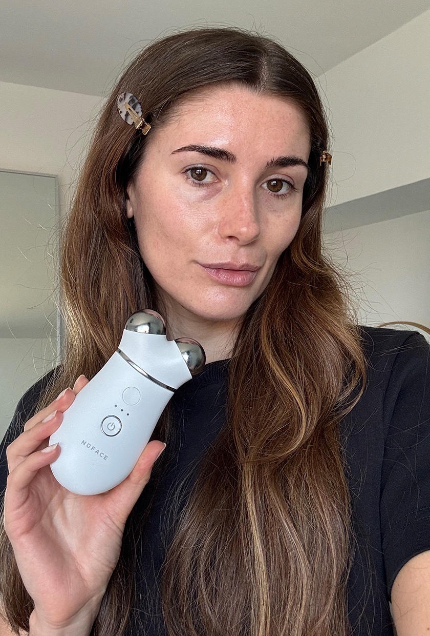 Who What Wear UK beauty editor Eleanor Vousden holding the NuFace Trinity to camera after testing it on her face