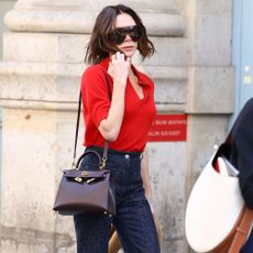 Victoria Beckham wears a red collared knit with Victoria Beckham Alina jeans.