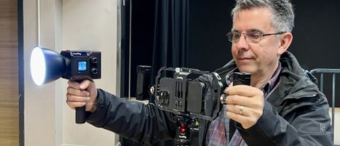 Man holding a SmallRig RC 60B COB video light and an iPhone in a camera rig