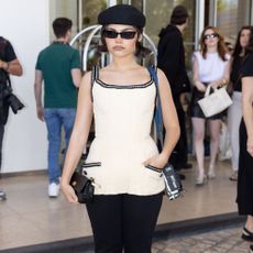 Ariana Greenblatt wears capri pants with black pumps and a black beret.