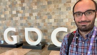 Michael Hicks stands in front of the GDC sign at GDC 2024
