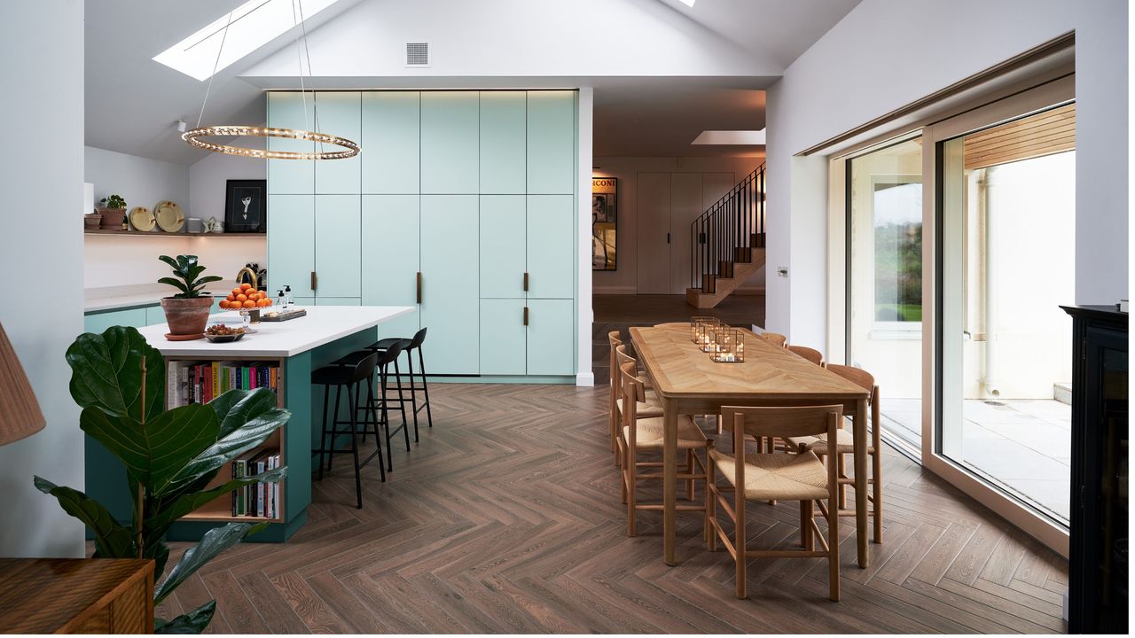 Kitchen diner open plan renovation with blue cabinets and statement light