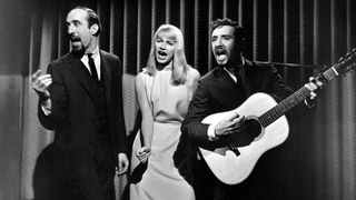 Peter, Paul &amp; Mary perform onstage in 1965 – Yarrow can be seen on the far right