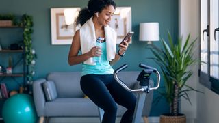 Woman using an exercise bike, part of the cheap gym equipment deals