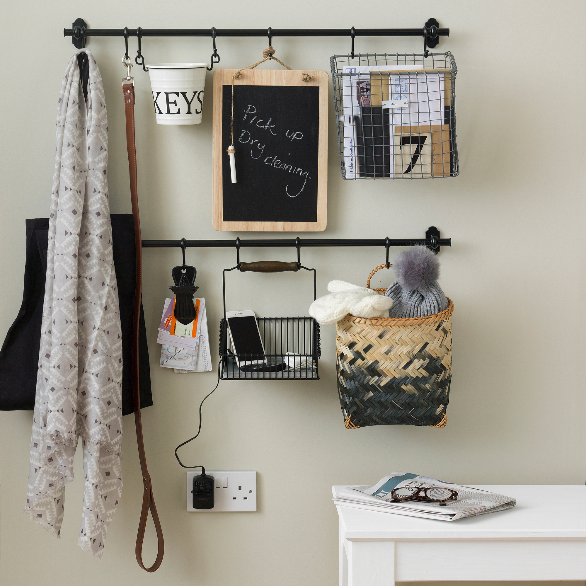 Black hanging rails used to hang kitchen items and baskets for organising