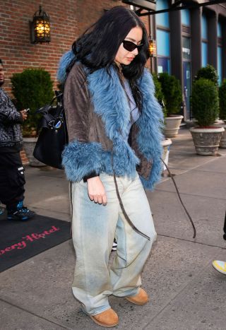 Charlie XCX in blue fur, baggy jeans, Uggs and sunglasses.