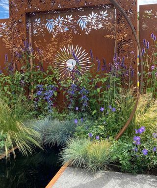 corten steel screens behind pond in 'Sunburst' garden, designed by Charlie Bloom and Simon Webster