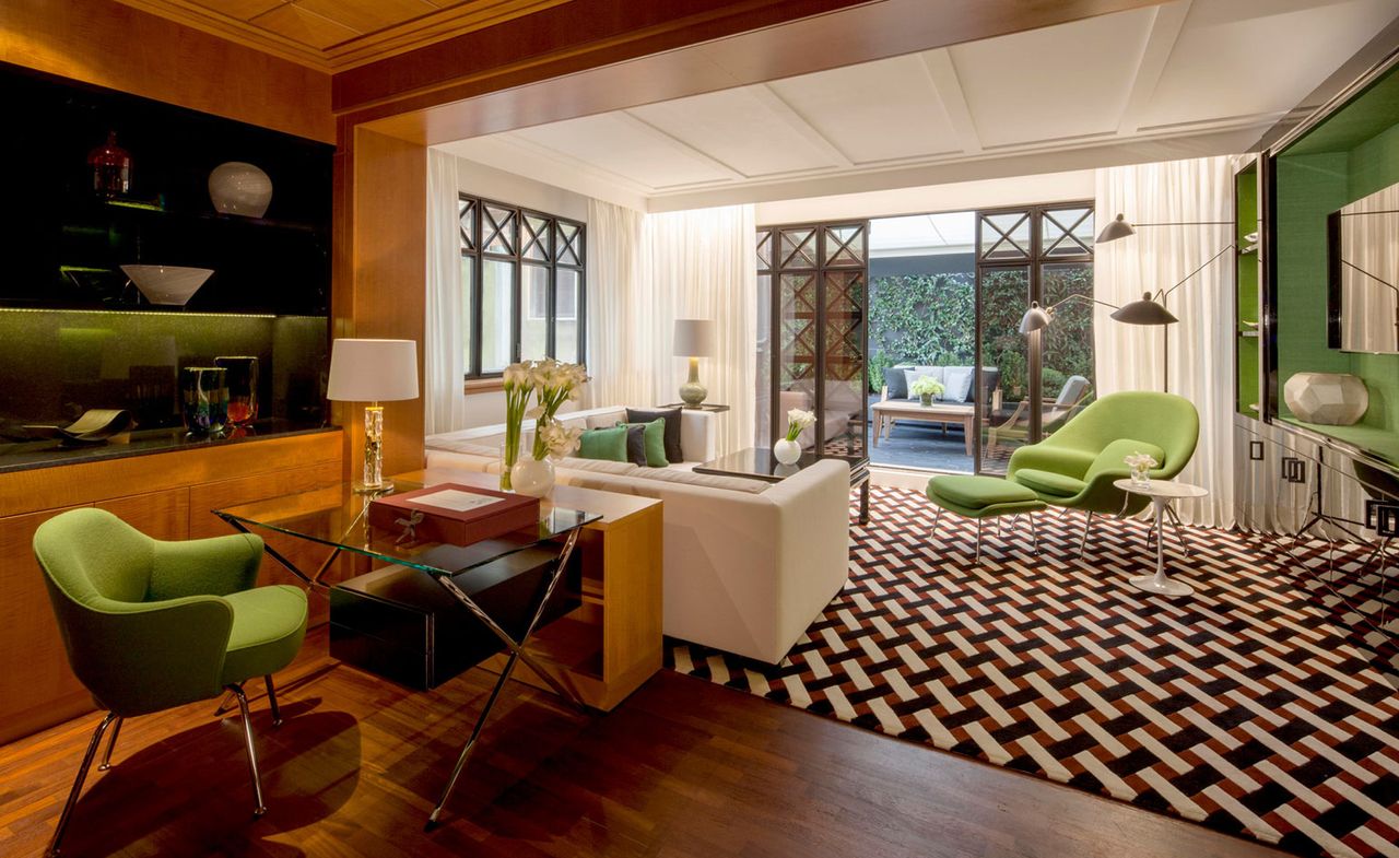 A sitting area with a sofa and chairs, double doors leading to an outside area at the Four Seasons Hotel — Milan, Italy