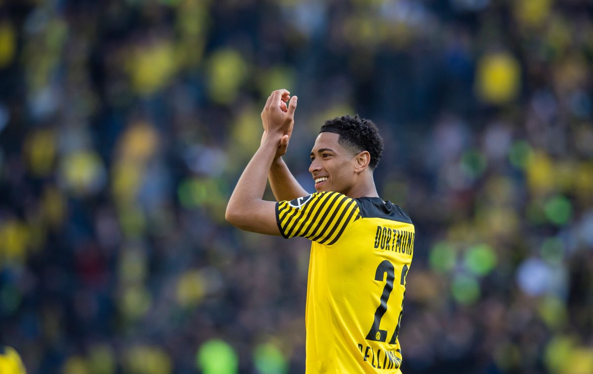 Borussia Dortmund midfielder Jude Bellingham smiling, applauding the fans