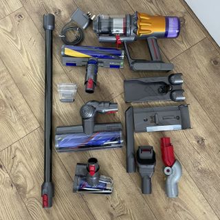 Dyson V12 Detect Slim parts and attachments, arranged on wooden floor
