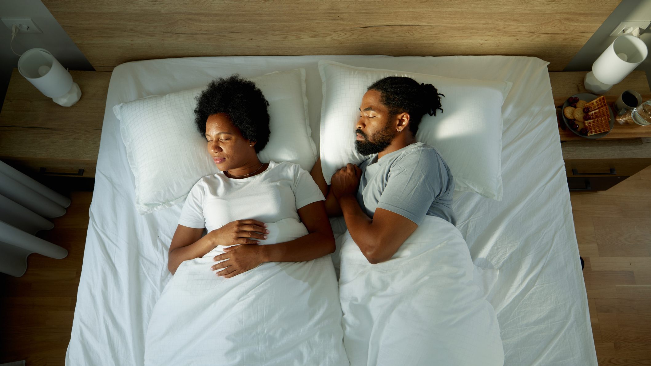 Man and woman asleep in a bed, seen from above