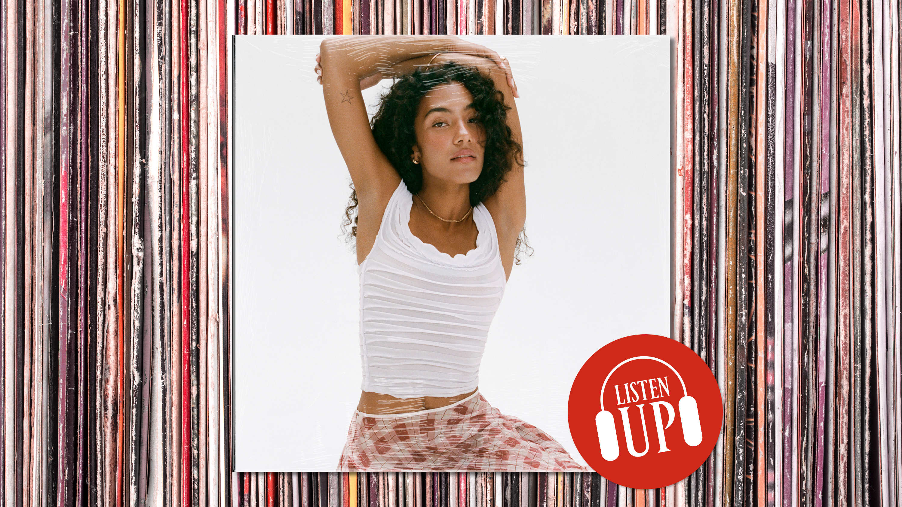 an image of singer olivia dean in a white shirt and red check skirt lifting her hands over her heads the logo for marie claire's listen up franchise on top