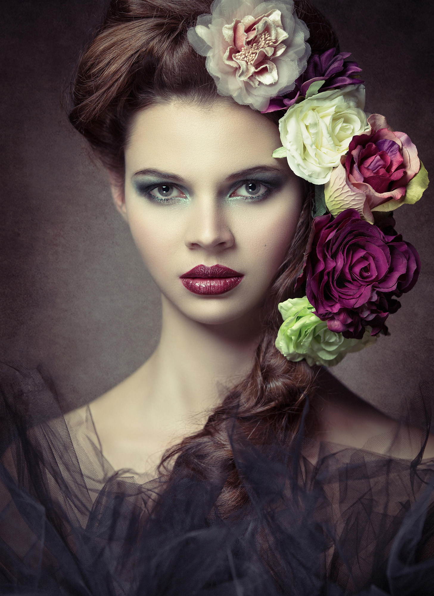 Studio portrait of model with white, purple and green flowers in hair