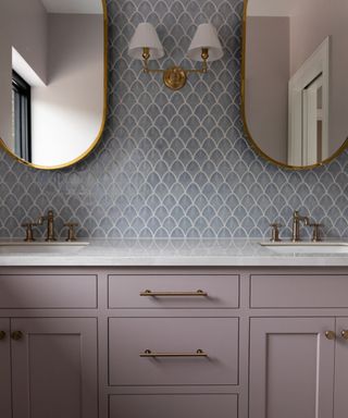 powder room with lilac vanity, blue tiles, white countertop and double mirrors