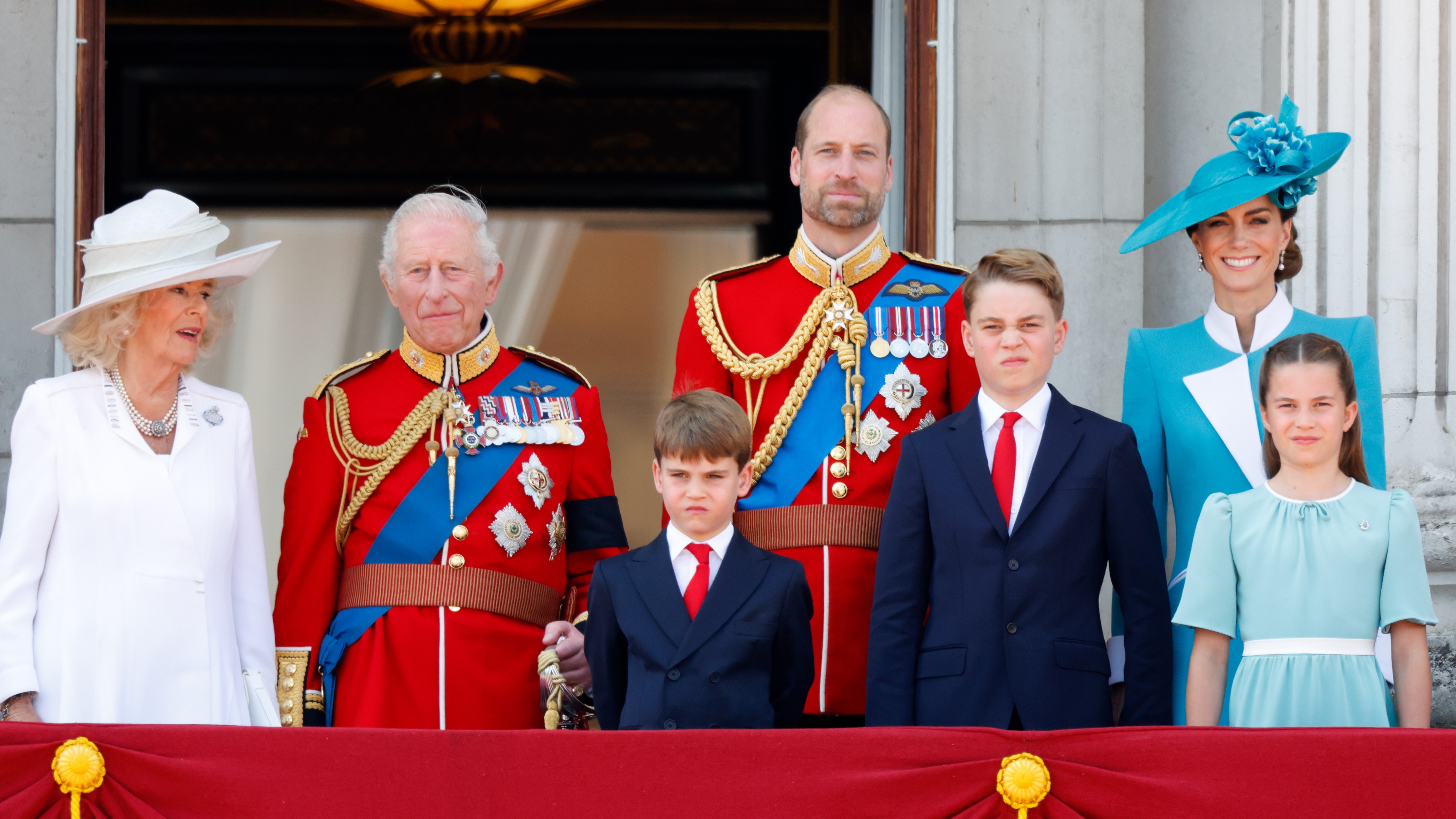 Queen Camilla, King Charles III, Prince Louis of Wales, Prince William, Prince George of Wales, Catherine, Princess of Wales and Princess Charlotte of Wales watch an RAF flypast from the balcony of Buckingham Palace