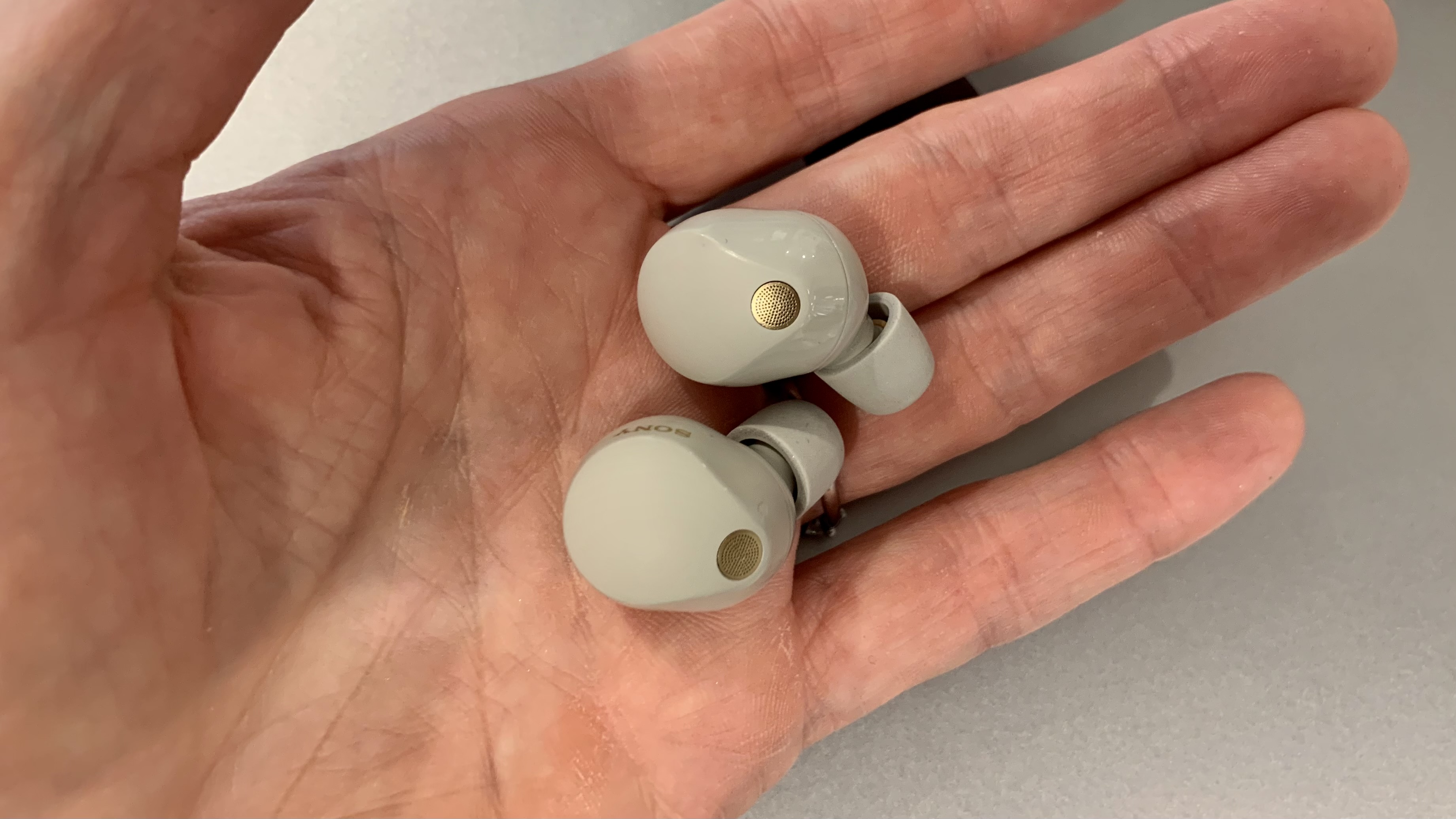 Sony WF-1000XM5 earbuds in the palm of a hand