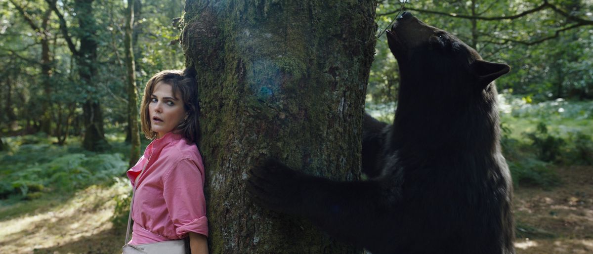 (L to R) Keri Russell as Sari, hiding from, the bear in Cocaine Bear