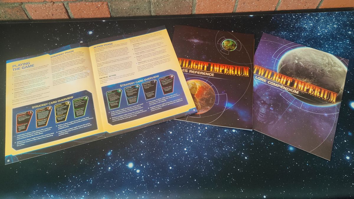 The Twilight Imperium rulebooks, laid out on a starry surface
