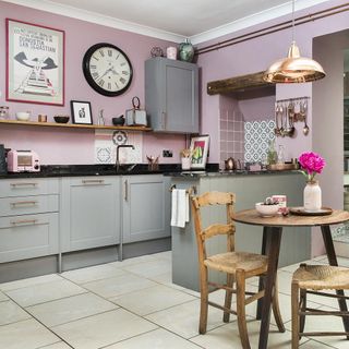 kitchen with pink wall wooden table and chair