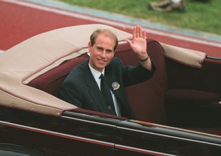 Prince Edward riding in a red convertible with no top in 1994