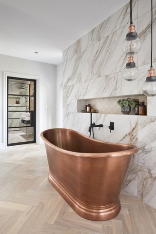 A copper bathtub in an all-white bathroom