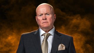 Phil Mitchell wearing a suit surrounded by yellow smoke.