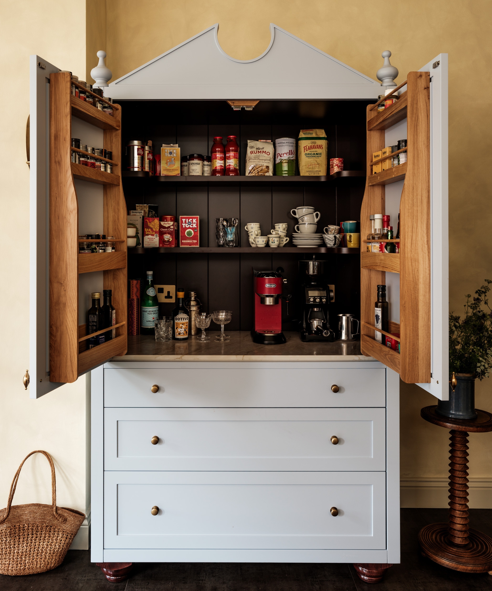 A pale blue freestanding larder with decorative spindle details and a mix of drawers, shelf, and door rack storage